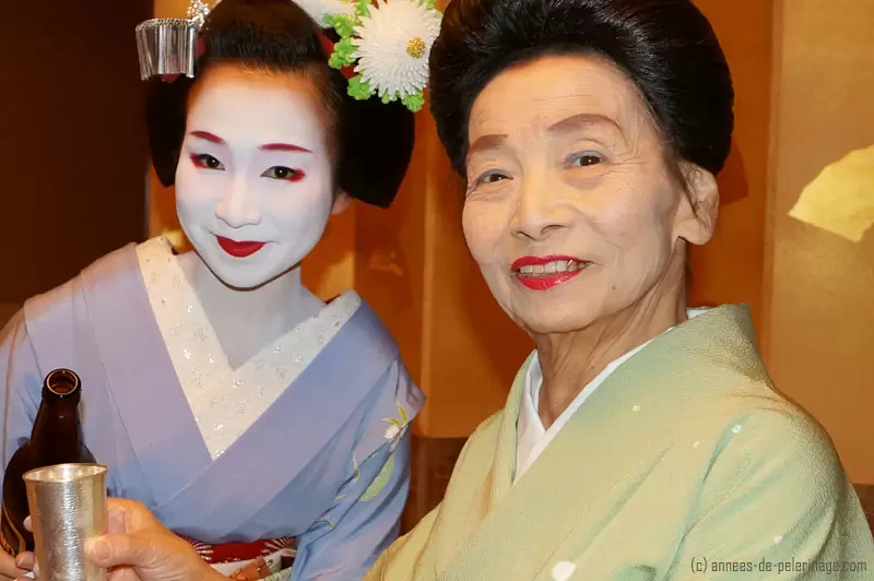 close-up portrait of a maiko (ふく真莉)refilling the pitcher of her older sister at the geisha party