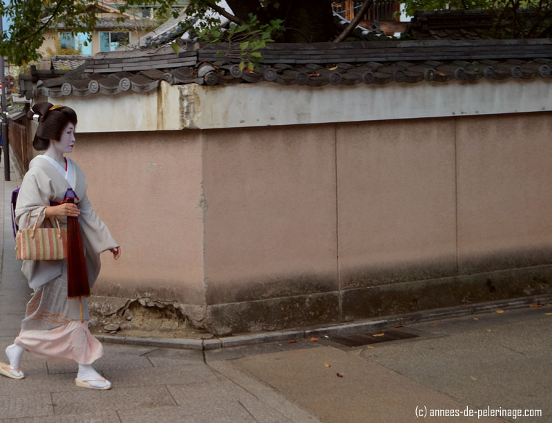 geisha (meiko) passing around a corner in gion, kyoto