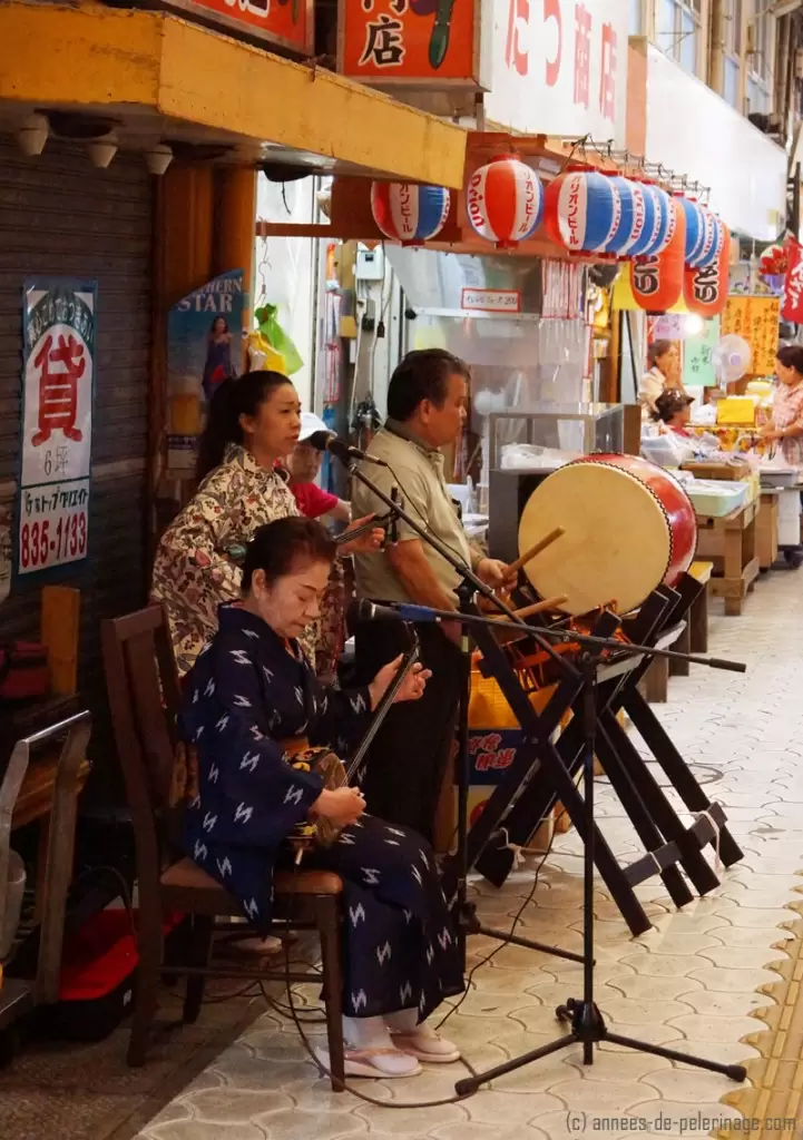 Watching a street band performing traditional music while walking through the shopping district of Naha