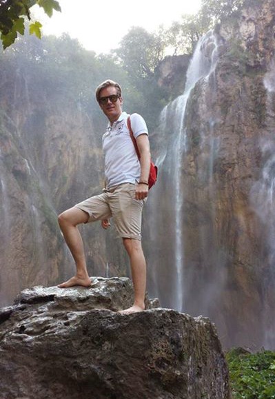 Me on a rock in front of the large waterfall in Plitvice Lakes National Park