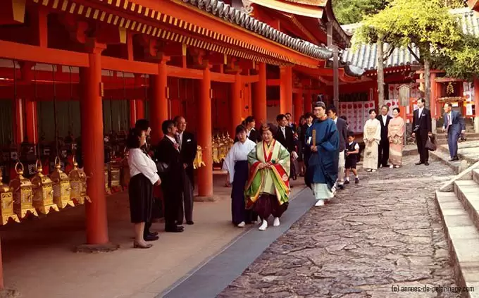 A wedding couple dressed like a japanese court noble woman from the Nara period wearing a junihitoe at Kasuga-Taisha in Nara