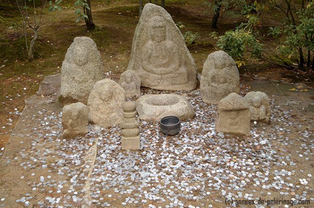 Weather worn statues and many coins scattered around the floor - supposedly for luck