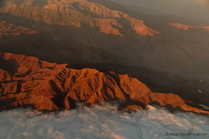 Flight over the andean mountain range hidden in the clouds close before lima, peru