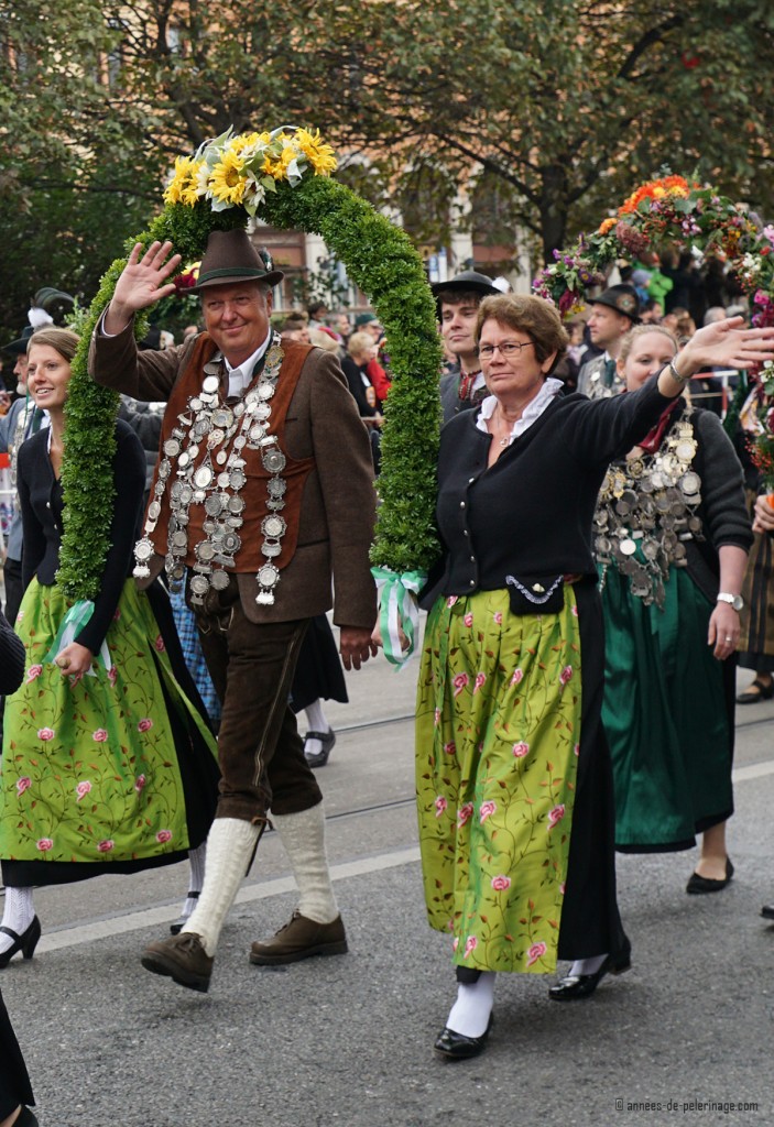 A champion marksman walking under a flower arch with his silver medals around his neck