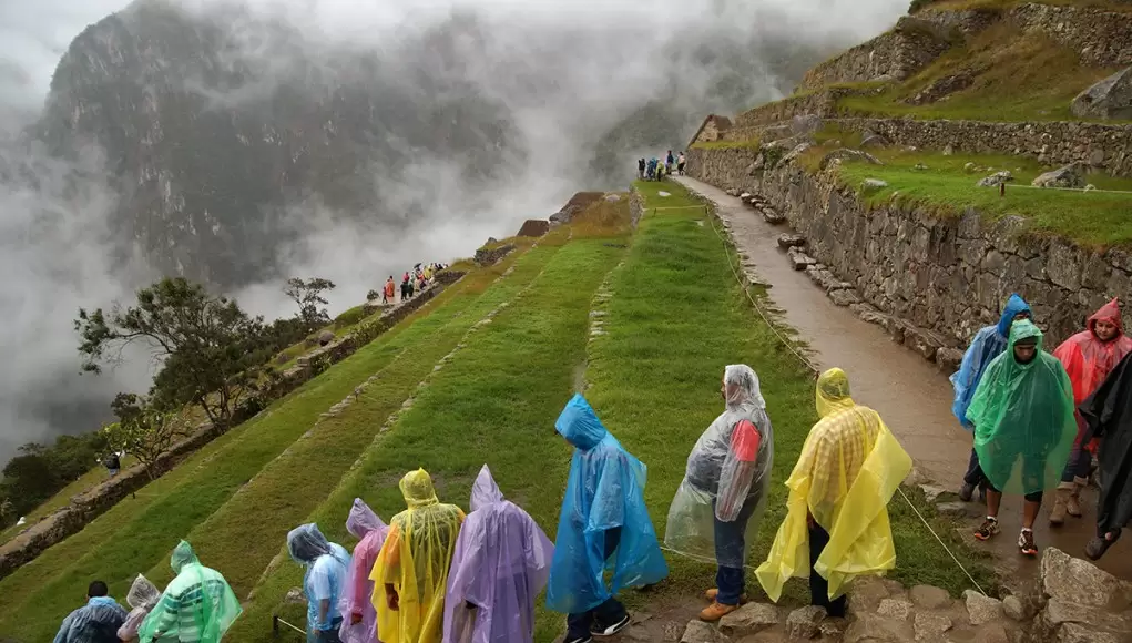 A crowd of tourists wearing rain capes in Machu Picchu