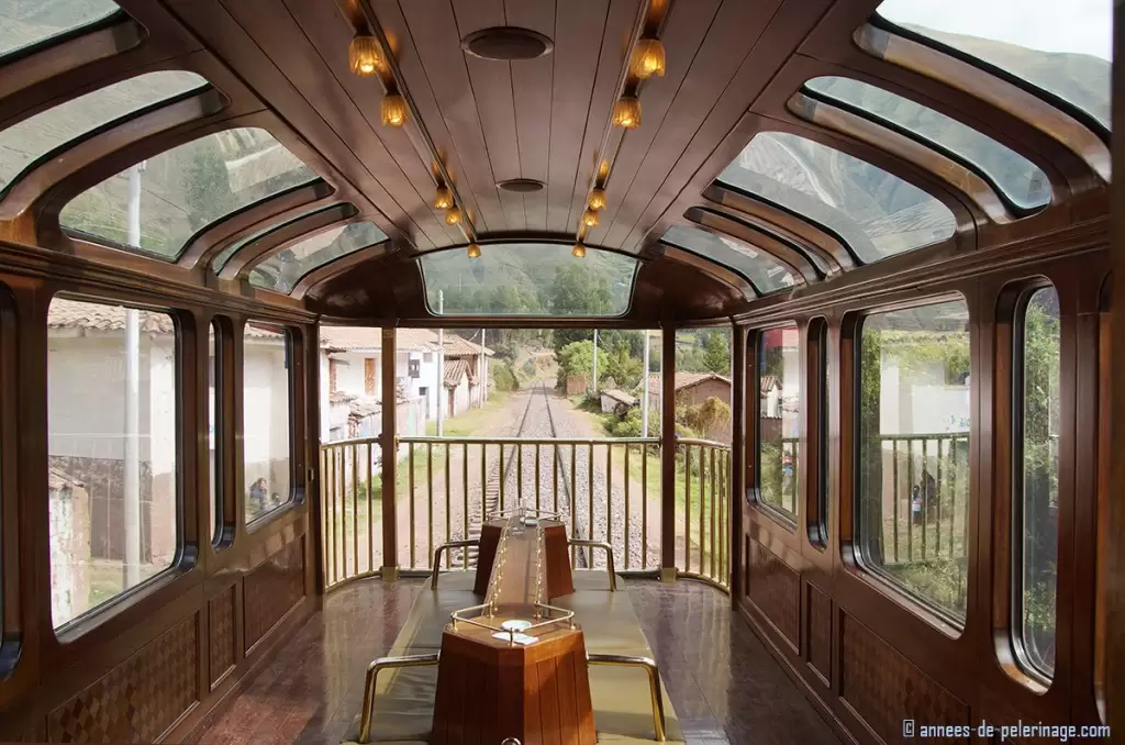 Observation deck of the Andean Explorer luxury train with a village visible through the huge windows