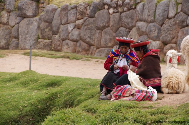 Two local womean knitting at the foot of the ruins of Sacsayhuamán in Cusco, Peru