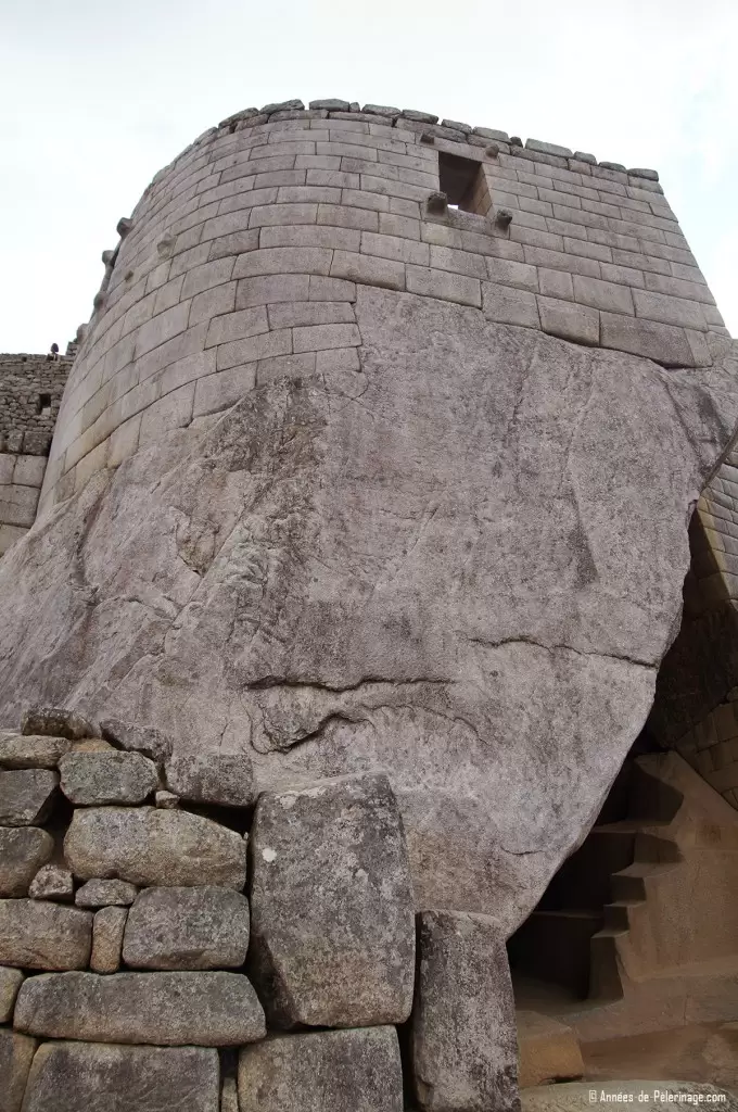 The temple of the Sun inside Machu Picchu with the royal tomb visible below