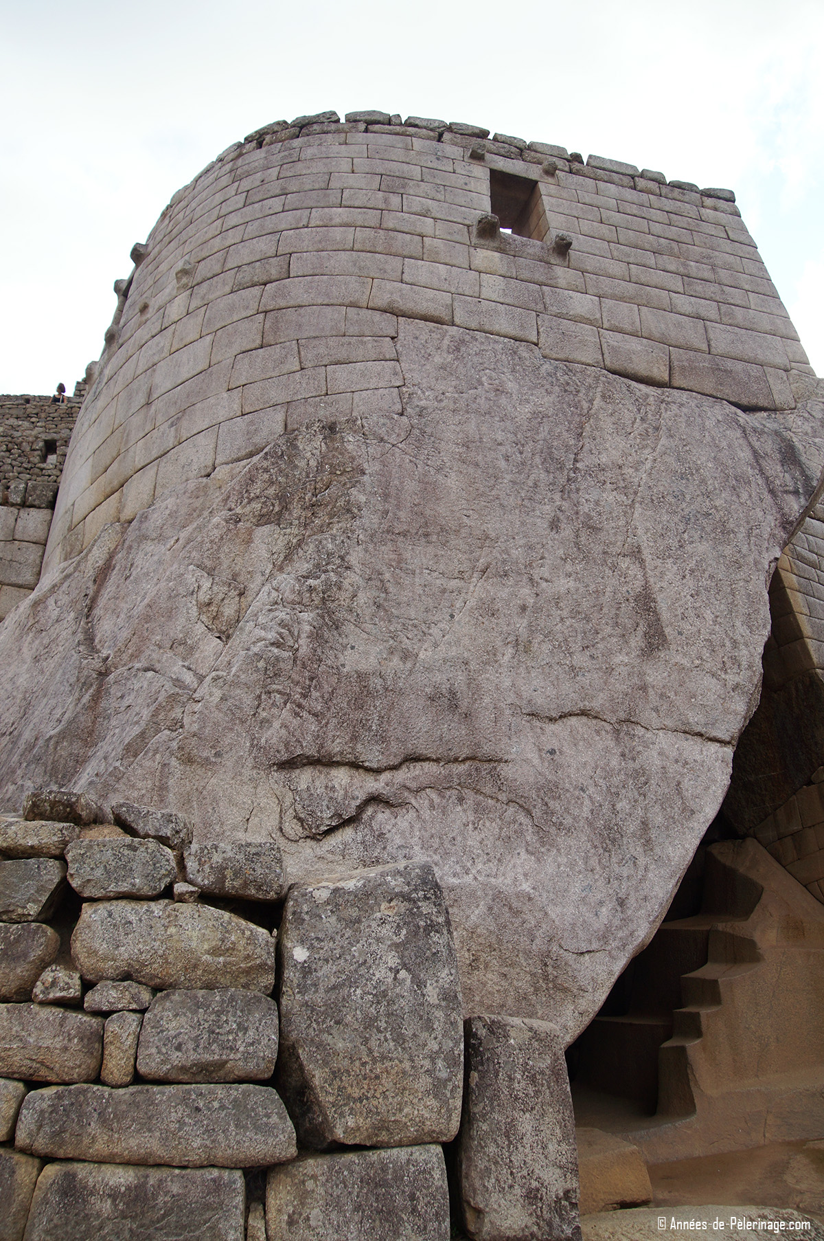 The temple of the Sun inside Machu Picchu with the royal tomb visible below. Unlike the rest of Machu Picchu architecture this structure has round walls