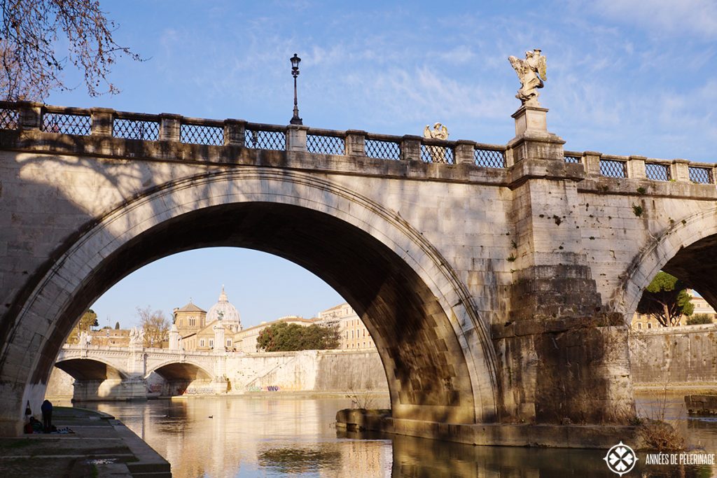 The banks of the Tibe river seen through the Angel Bridge and the Vatican in the background