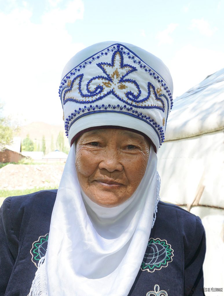 An old Kyrgyz woman in her traditional headdress. She is specialized on embroidery and felt making