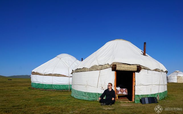 Me sitting in front of a yurt in Kyrgyzstan and my solar panel charging my mobile phone
