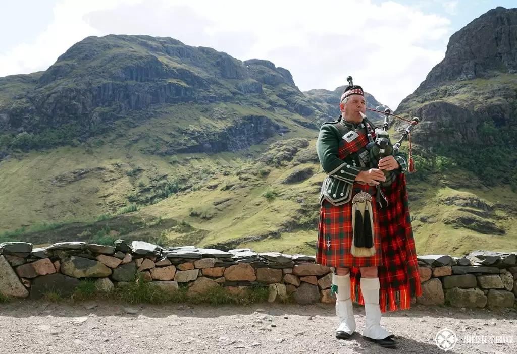 Glen Coe in Scotland and man playing bag pipes