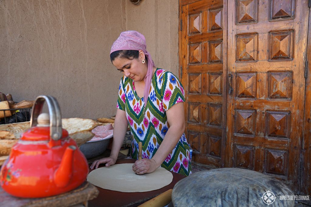 A woman wearing traditional clothes and preparing traditional uzebkistan break in Khiva