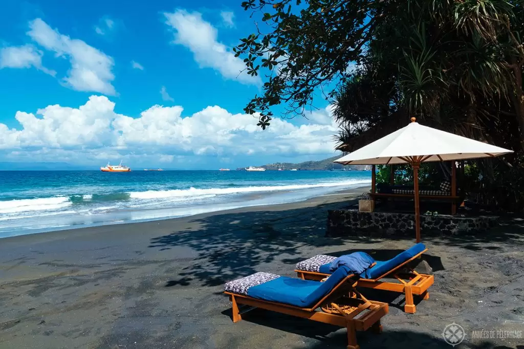 A traditional bale hut and sun loungers at the private beach of the Amankila Beach Club in East Bali