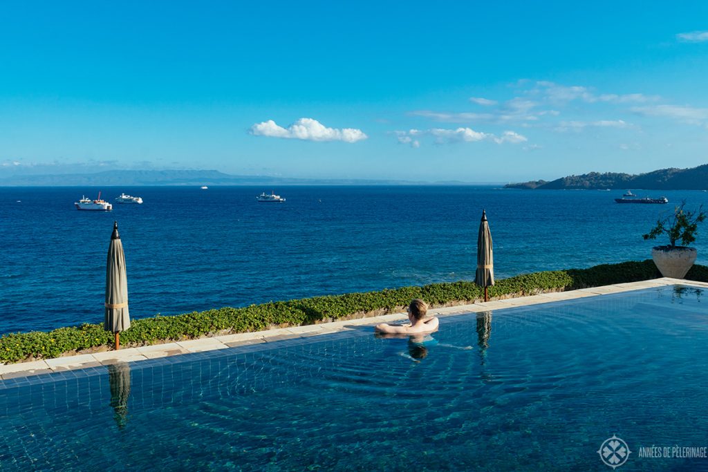 lounging in the infinity pool of the amankila luxury resort in East Bali