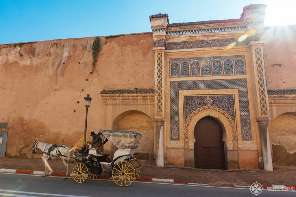 A carriage driving along the old palace walls in Meknes, Morocco