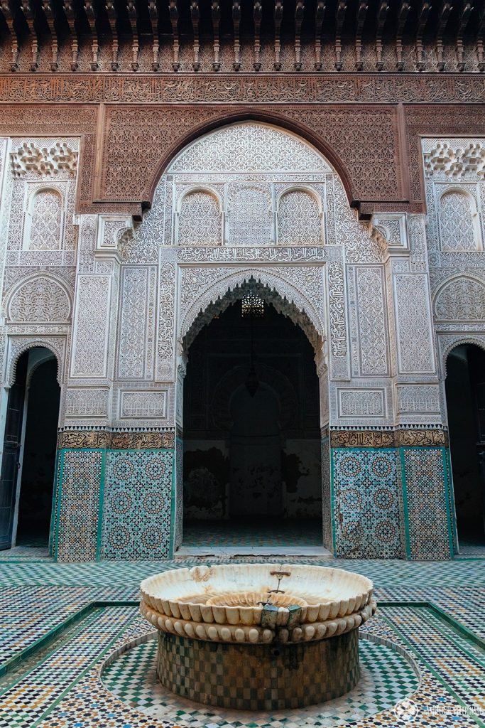 The inner courtyard of the Bou Inania Madrasa with a fountain for ritual washing before the pray. A must-see in Meknes, Morocco