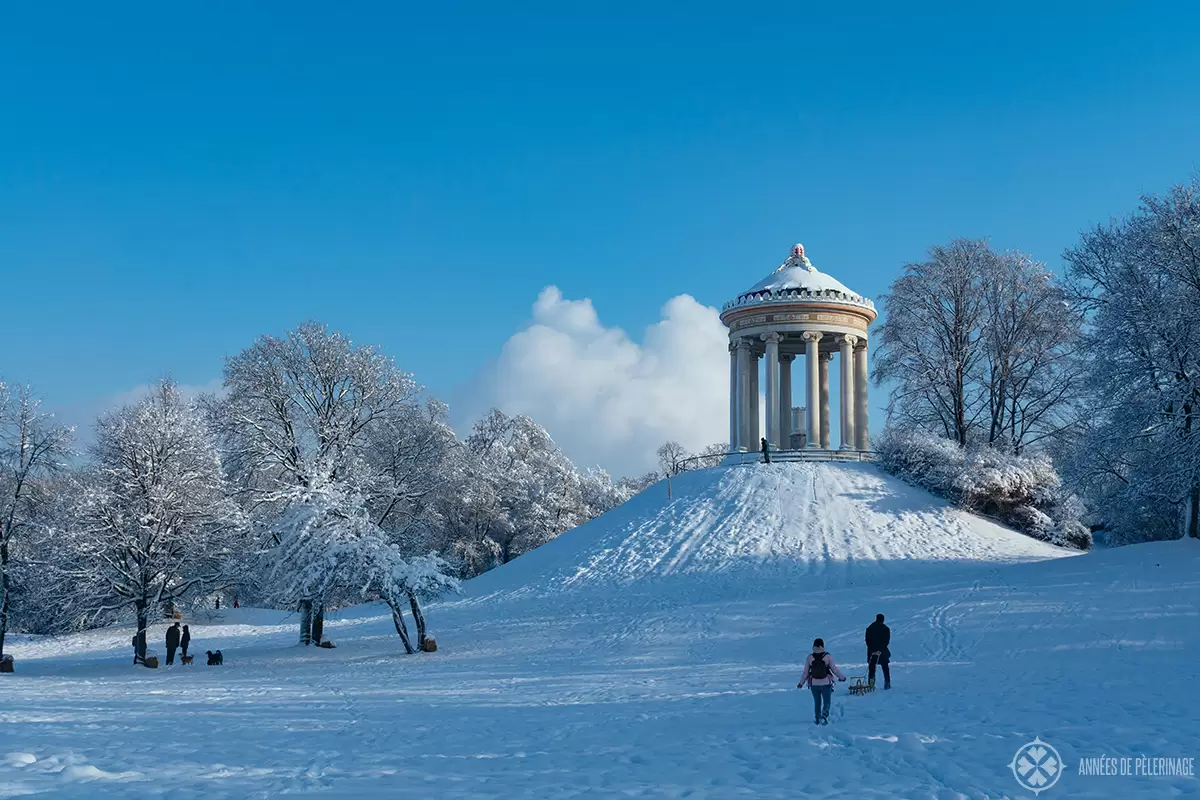 Sledding down the hill of the Monopteros in Munich in winter