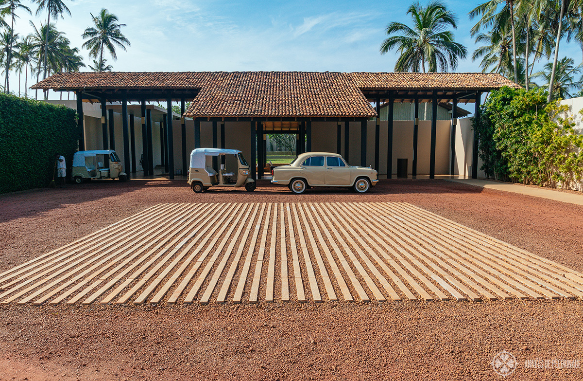 The lobby of Amanwella with a couple of tuk-tuks and a vintage car in front of it