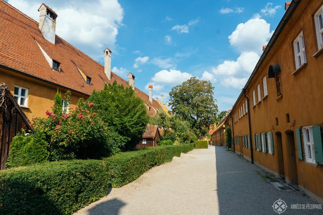 An alley inside the Fuggerei with beautiful little back gardens - one of the best places to visit in Augsburg