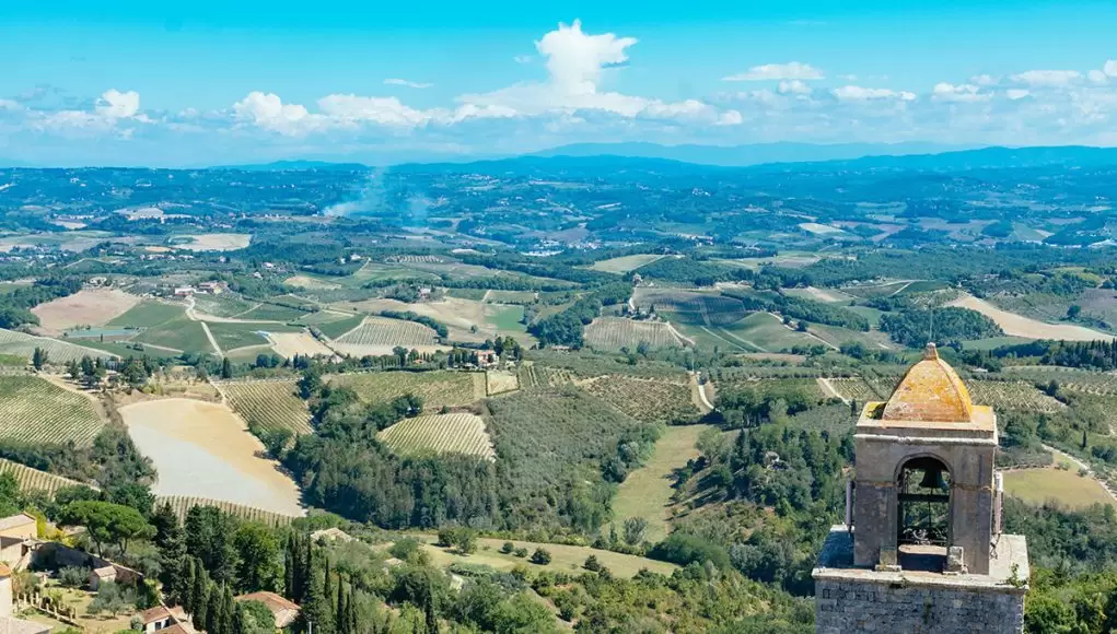 The best things to do in Tuscany, Italy. This picture shows a view of the the famous Tuscan landscape from San Gimigano