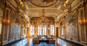 The main restaurant on the second floor of AMan Venice, with golden stucco work, chandeliers and frescos all over