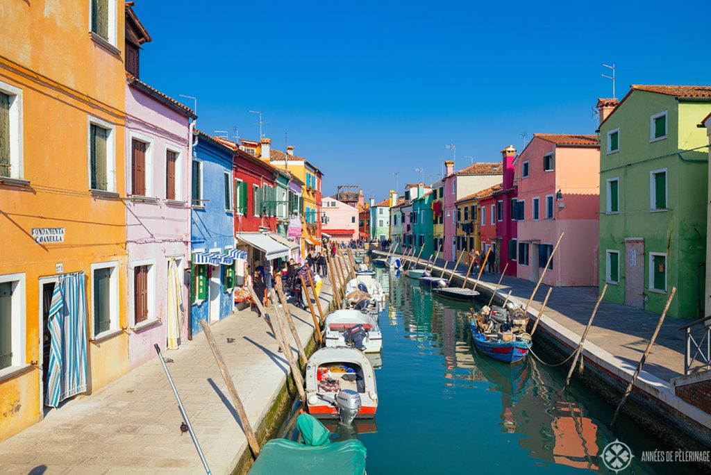 The picturesque main water channel on the island of Burano with many tiny colorful houses on each side of the water