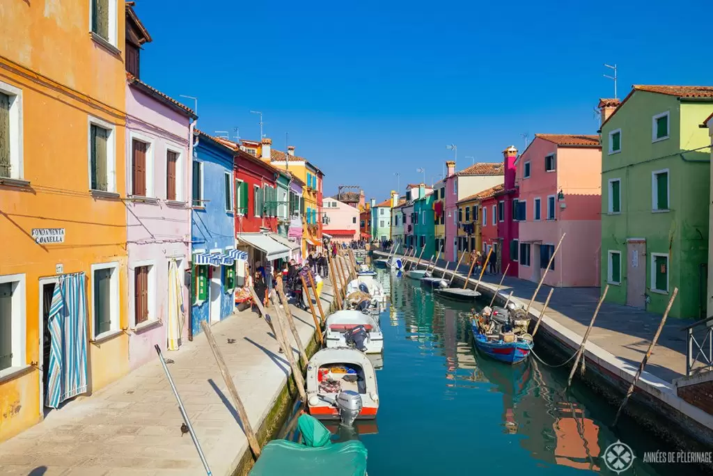 The picturesque main water channel on the island of Burano with many tiny colorful houses on each side of the water