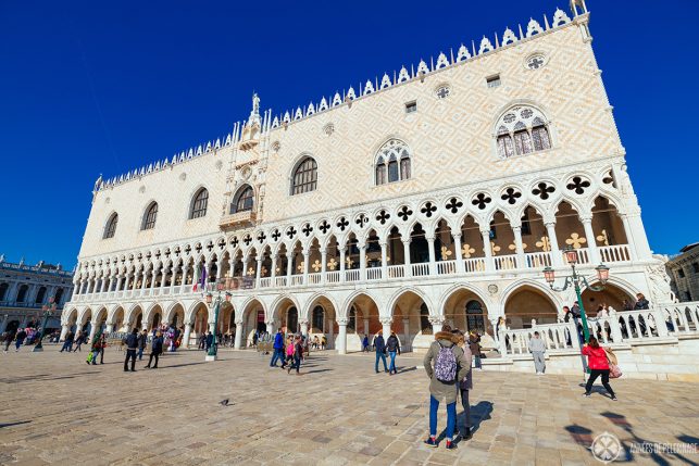 The facade of the Doge's Palace - all white marble. A tier of gothic arches with four leafed rosettas is topped by a larger tier in a pattern reminisicent of persian rugs