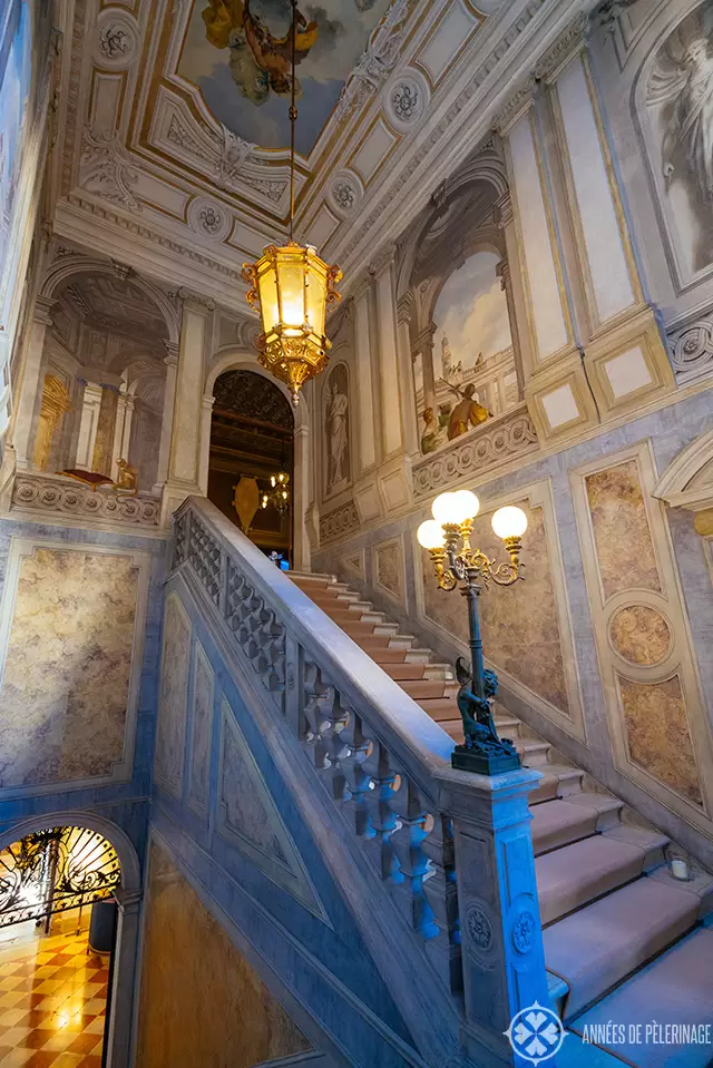 The main staircase of Aman Venice with beautiful frescoes lamps and marble inlays