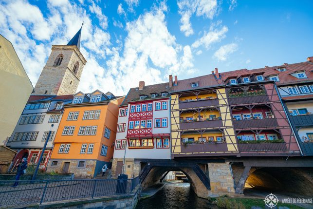 THe fantastic krämerbrücke with colorful half-timbered houses lining the lenght of the bridge in Erfurt with the Aägiden church