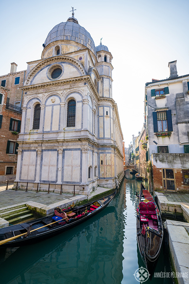 A couple of gondolas waiting for customers in front of Santa Maria dei Miracoli church in venice