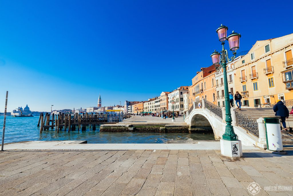 A bridge at the waterfront of Venice with St. Mark'S belltower in the far background