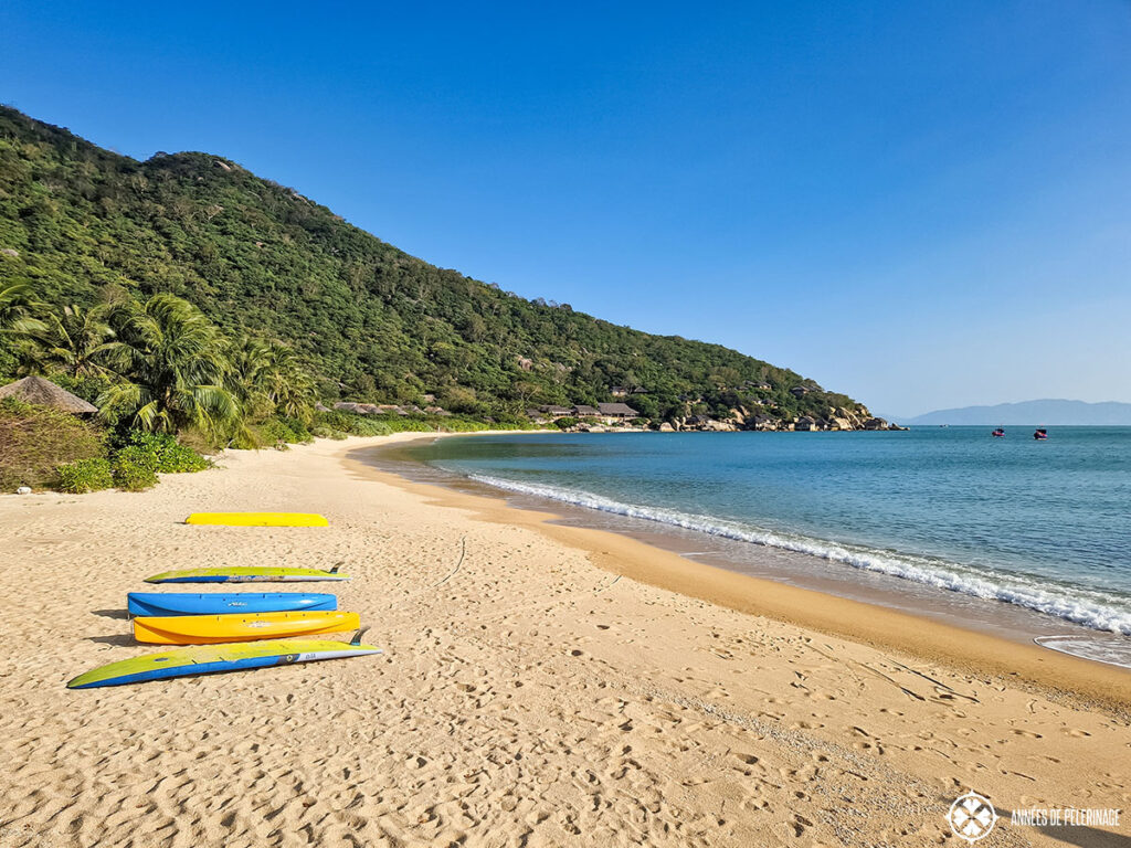 the beach of the Six Senses Ninh Van Bay with some canoes in front of it