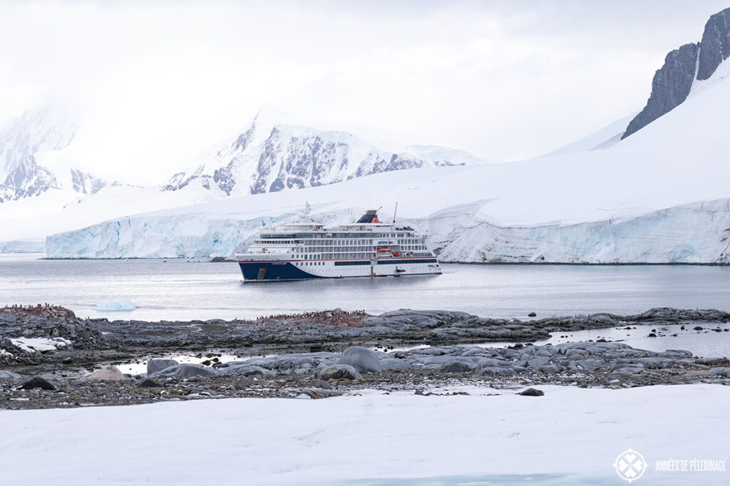 an antartic expedition cruise ship in front of a glacier