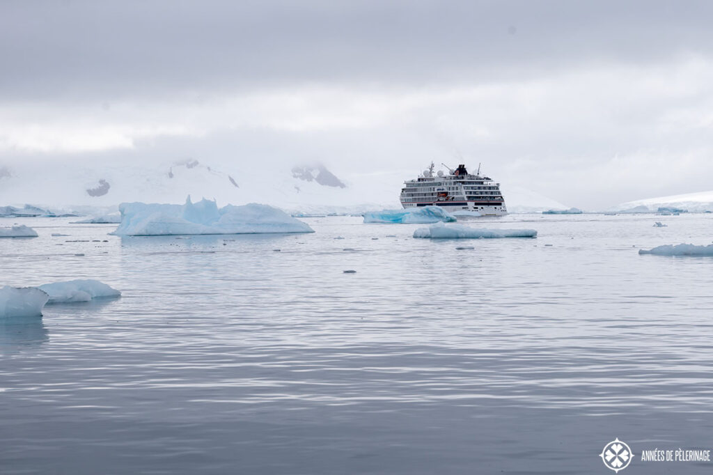 a cruise ship on the water in Antartica overcast sky