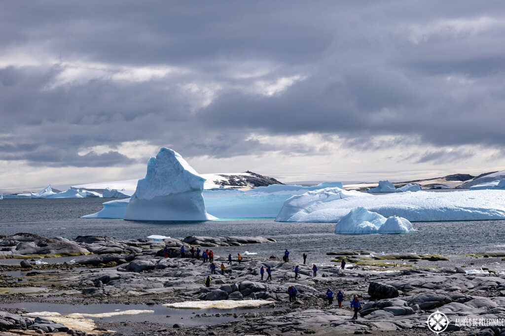 cruise ship passengers in antartica exploring a landing site in sunshine