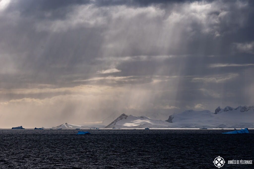 dramatic skies with blue icebergs on the water