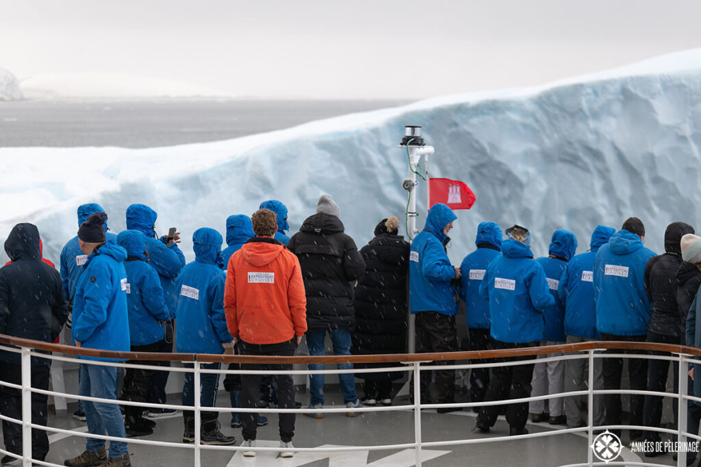 passengers standing on the bow of a cruise ship to touch an ice berg