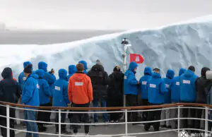 passengers standing on the bow of a cruise ship to touch an ice berg