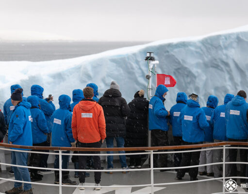 passengers standing on the bow of a cruise ship to touch an ice berg